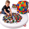 Child building on the open BrickPack playmat beside the colorful backpack